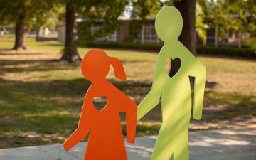 yellow mister walker statue with orange child statue